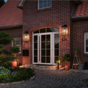 Wall lanterns lit at dusk on a brick house